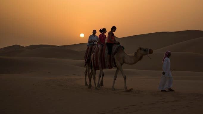 Photography of People Riding Camel during Sunset